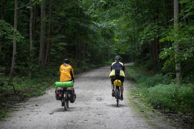 two cyclists on wooded biking trail