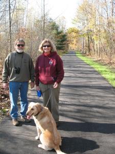 Couple walking there dog on a paved Trail