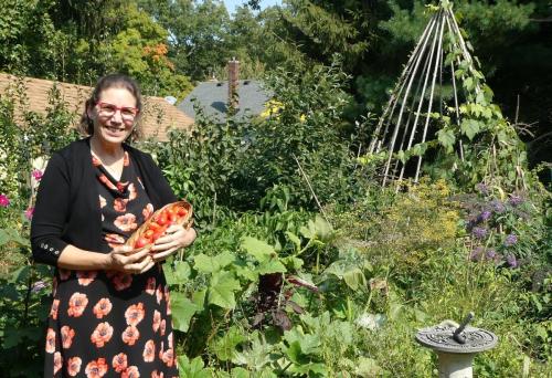 woman in garden with tomatoes smiling