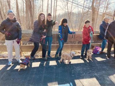 outdoor photo of several individuals with puppies along the trail