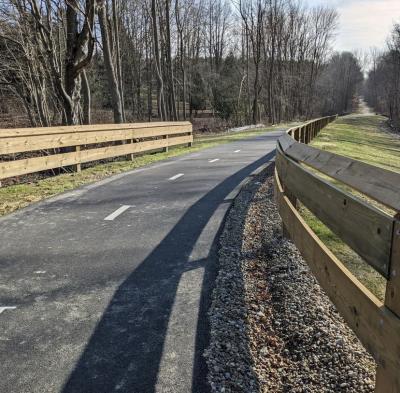 photo of winding paved trail with fenced railing 