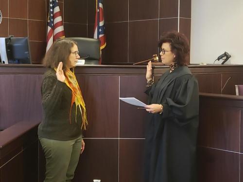 woman being sworn in by judge in courtroom