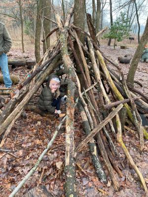 Child den building at nature play space.