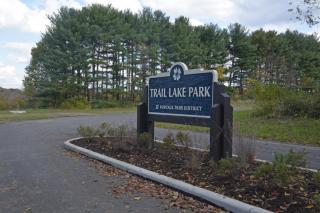 Trail Lake Park entrance sign with evergreen trees in background