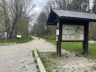 View of park kiosk in foreground and limestone paved trail in background