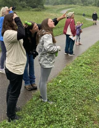 people of all ages using binoculars to spot birds 