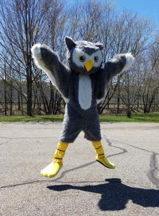 Owlbert, the Portage Park District mascot, jumps in the air with his wings out.