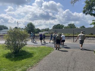seniors hiking on a paved path under the sun