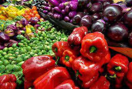 rainbow of fresh vegetables; red peppers, purple eggplants, green brussel sprouts, orange carrots