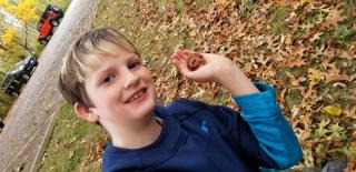 young boy holding frog 