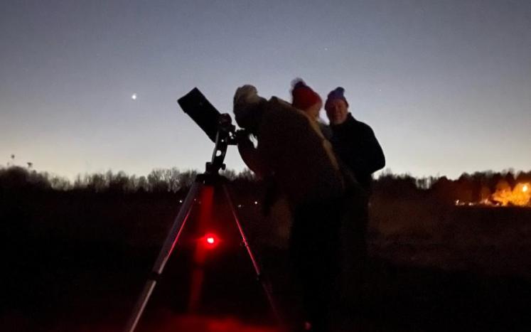 stargazers using a telescope