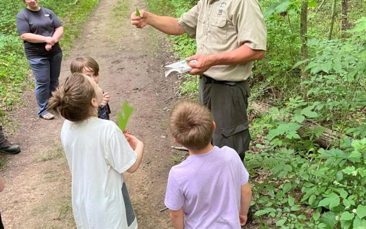 man showing kids how to identify trees